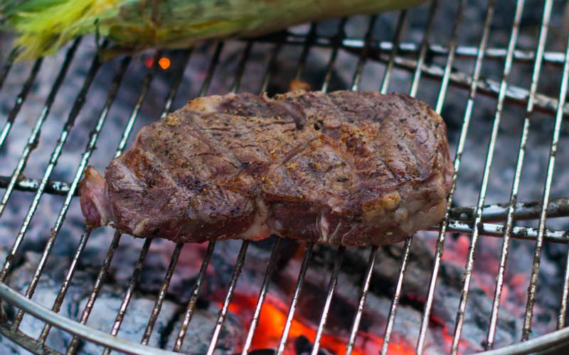 Steak being cooked over an open fire