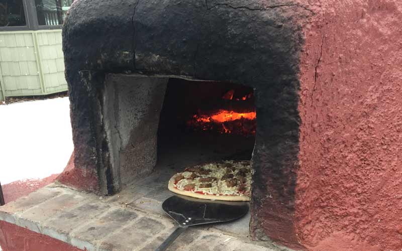 Pizza being baked in the Glanville's wood fired oven