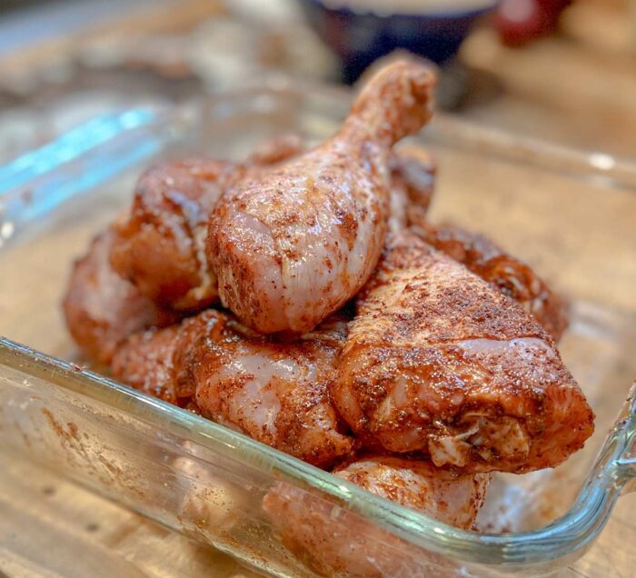 Chicken legs that have been seasoned and are ready for the smoker.